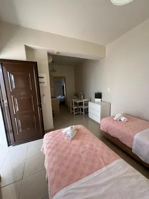 a hotel room with two beds and a kitchen at Steve's Beach in Faliraki