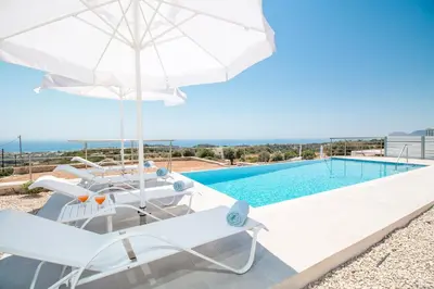 a villa with a pool and chairs and an umbrella at Francis & Gregorys Luxury Villas in Afantou