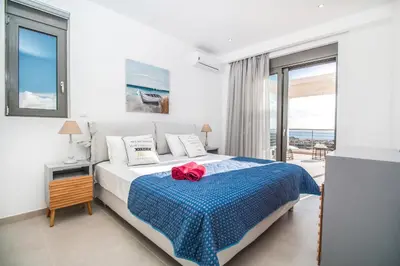 a bedroom with a bed with a red rose on it at Francis & Gregorys Luxury Villas in Afantou