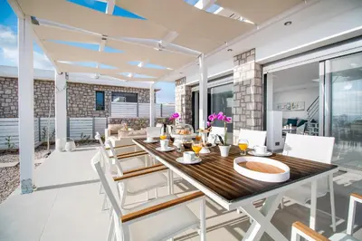 a dining room with a table and chairs at Francis & Gregorys Luxury Villas in Afantou
