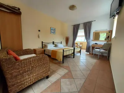 a hotel room with a bed and a couch at Courtyard Studios in Pefki Rhodes