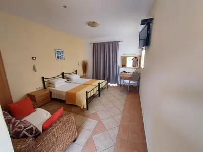 a hotel room with a bed and a couch at Courtyard Studios in Pefki Rhodes