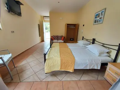 a bedroom with a large bed and a tv at Courtyard Studios in Pefki Rhodes