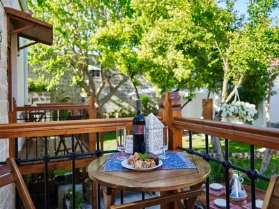 a table with a bottle of wine and a plate of food at Helios Garden Boutique Apartments in Rhodes Town