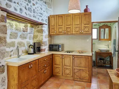 a kitchen with wooden cabinets and a sink at Helios Garden Boutique Apartments in Rhodes Town