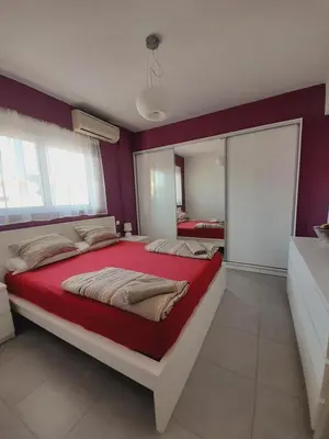 a bedroom with a large bed and a mirror at Kalithies apartment in Kalithies