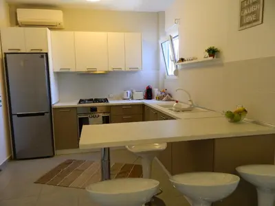 a small kitchen with a counter and a refrigerator at Kalithies apartment in Kalithies