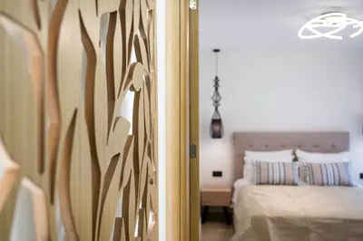 a bedroom with a bed and a wooden wall at Antigone Estate in Koskinou