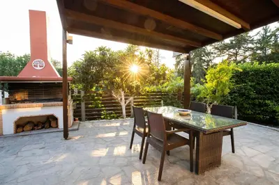 a patio with a table and a fireplace at Antigone Estate in Koskinou