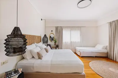 a white bedroom with a large bed and a couch at Bello Blu Luxury Villa in Asgourou