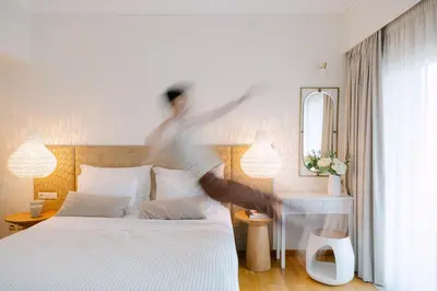 a person jumping on a bed in a bedroom at Bello Blu Luxury Villa in Asgourou