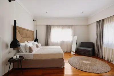 a bedroom with a bed and a chair and a window at Bello Blu Luxury Villa in Asgourou