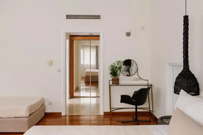 a bedroom with a bed and a chair and a mirror at Bello Blu Luxury Villa in Asgourou