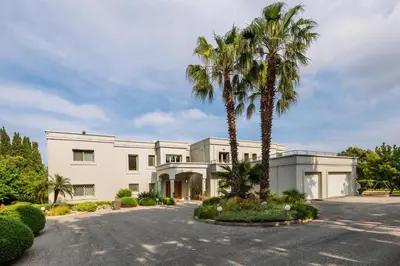a large white house with palm trees in the driveway at Bello Blu Luxury Villa in Asgourou