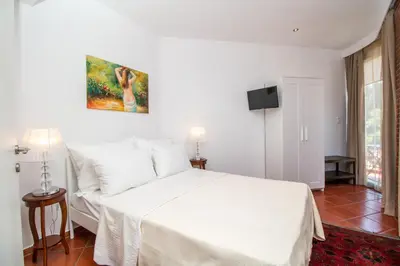 a bedroom with a white bed and a tv at Danezis City Stars Boutique Aparthotel in Rhodes Town