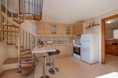 a kitchen with a staircase and a white refrigerator at Villa Fay in Lardos