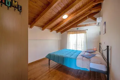 a bedroom with a bed and a wooden ceiling at Villa Fay in Lardos