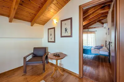 a room with a chair and a table and a bed at Villa Fay in Lardos