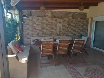 a patio with a table and chairs and a brick wall at Villa Fay in Lardos