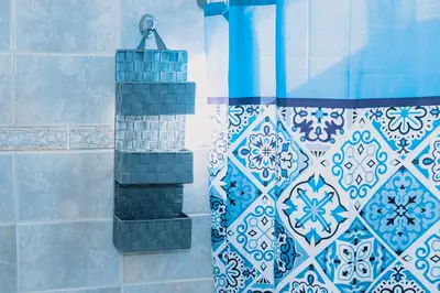 a shower with blue and white tiles and a shower curtain at Villa Stegna in Archangelos