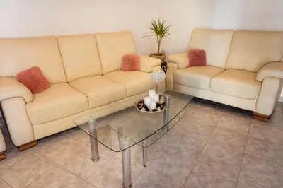 a living room with two couches and a glass table at Villa Stegna in Archangelos