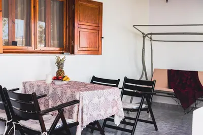 a dining room with a table with chairs and a cabinet at Villa Stegna in Archangelos