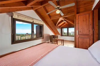 a bedroom with a bed and a ceiling fan at Villa Zoi in Gennadi