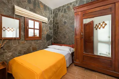a bedroom with a bed and a wooden cabinet at Villa Zoi in Gennadi
