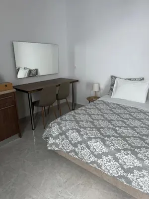 a bedroom with a bed and a desk and a mirror at Fedra Apartments Lindos in Líndos