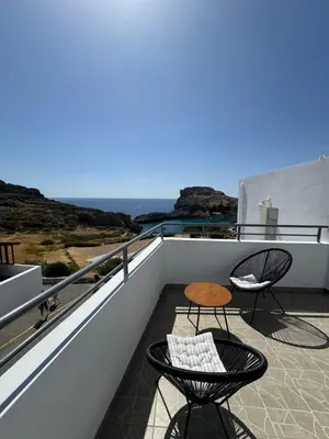 a balcony with two chairs and a table at Fedra Apartments Lindos in Líndos