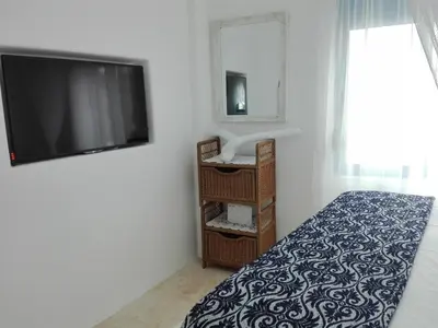 a bedroom with a bed and a flat screen tv at Tilos Island house in Megálon Choríon