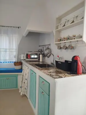a kitchen with green cabinets and a counter top at Tilos Island house in Megálon Choríon