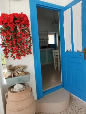 a blue door with a bouquet of red roses at Tilos Island house in Megálon Choríon