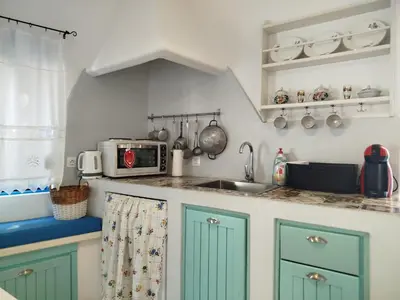 a kitchen with green cabinets and a sink at Tilos Island house in Megálon Choríon