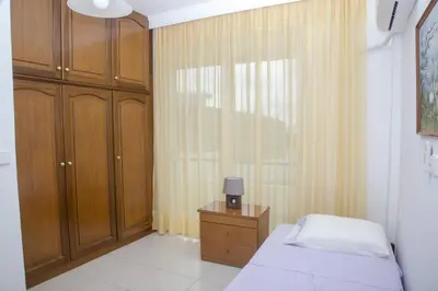 a bedroom with a bed and a dresser and a window at Aggeli Village House in Asklipiḯon