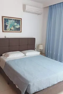 a bedroom with a large bed with blue curtains at Aggeli Village House in Asklipiḯon