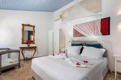 a bedroom with a white bed with towels on it at Amelie Villa in Ixia