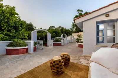 a house with a patio with a couch and two logs at Amelie Villa in Ixia