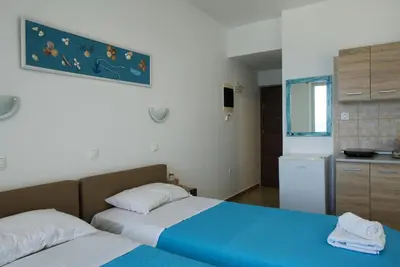 a bedroom with two beds and a kitchen at Lilian's Seaview-Party Street-Youth Studios in Rhodes Town
