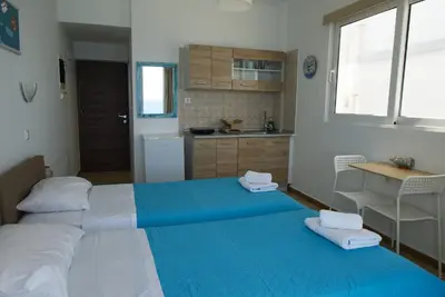 a bedroom with two beds and a kitchen at Lilian's Seaview-Party Street-Youth Studios in Rhodes Town