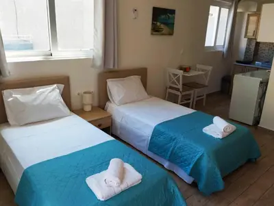 two beds sitting next to each other in a room at Lilian's Seaview-Party Street-Youth Studios in Rhodes Town