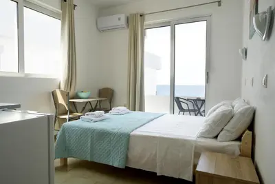 a bedroom with a bed with a view of the ocean at Lilian's Seaview-Party Street-Youth Studios in Rhodes Town
