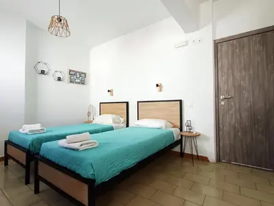 a bedroom with two beds with towels on them at Lilian's Seaview-Party Street-Youth Studios in Rhodes Town