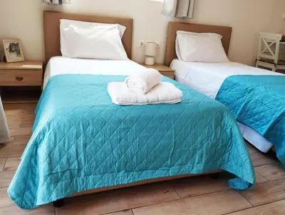 two beds with towels sitting on top of them at Lilian's Seaview-Party Street-Youth Studios in Rhodes Town