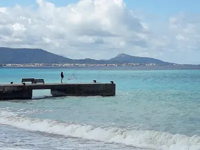 a person standing on a pier in the ocean at Lilian's Seaview-Party Street-Youth Studios in Rhodes Town