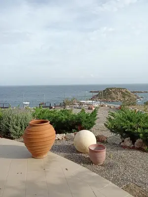 three large pots sitting on the ground near the ocean at Casa di Mare Stegna in Archangelos