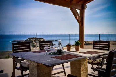 a table with wine glasses sitting on top of the beach at Casa di Mare Stegna in Archangelos