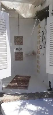 a room with a white wall with a chandelier at Casa di Mare Stegna in Archangelos