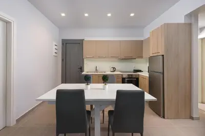 a kitchen with a white table and black chairs at Lardos Luxury Apartments in Lardos