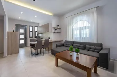 a living room and kitchen with a couch and a table at Lardos Luxury Apartments in Lardos